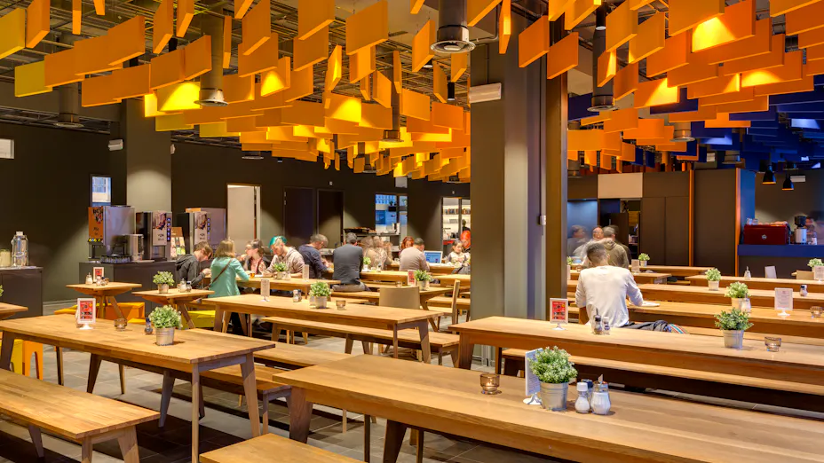 Interior design view of a yellow baffle ceiling at MEININGER Hotel Amsterdam City West