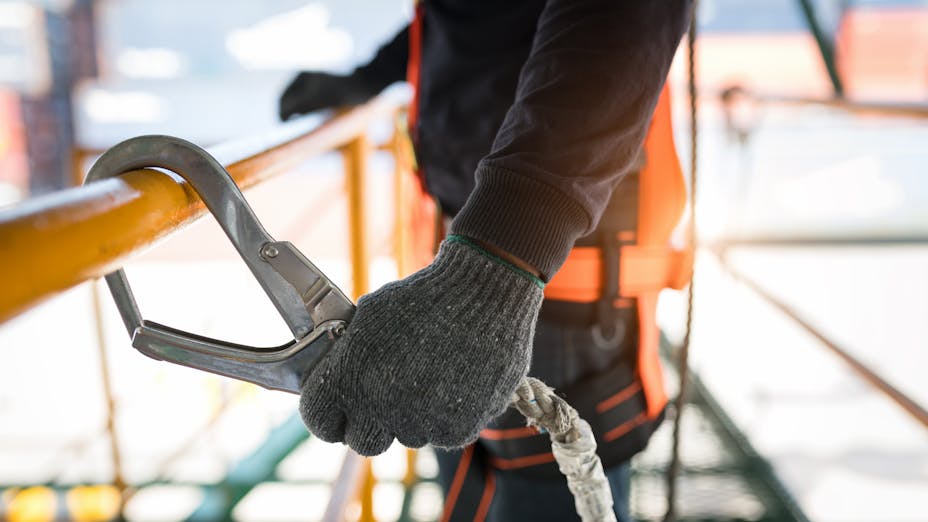 Worker safely hatched on to railing with a line