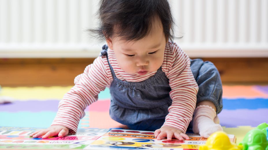 Small child playing with book