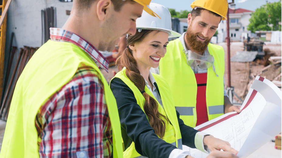 Three engineers looking at building plans.