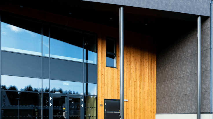 Sports hall 'Lärkan' in Sala, Sweden cladded with Rockpanel Stones Mineral Rust and Basalt Iron facade cladding.