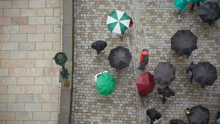 Birds-eye view, umbrellas in street, rain. Photo used first in the Sustainability Report 2017