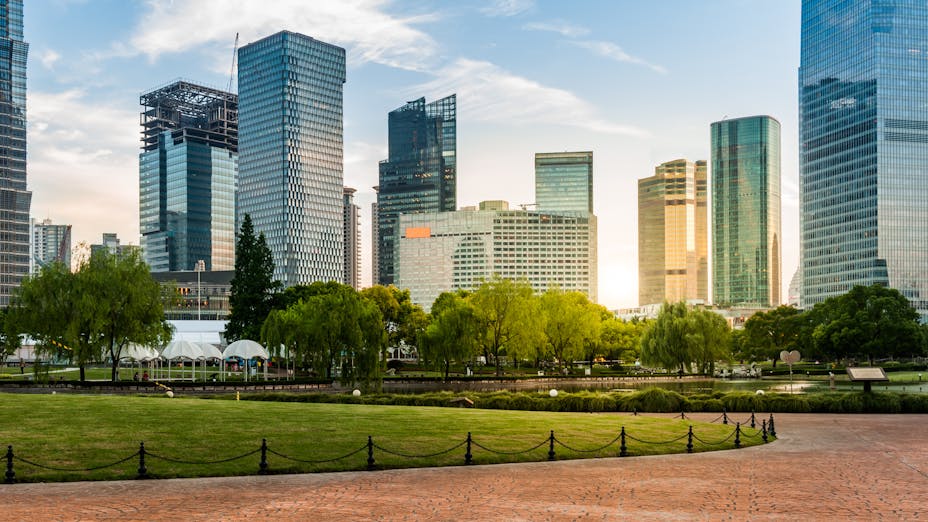 A green park with high rise building in the background