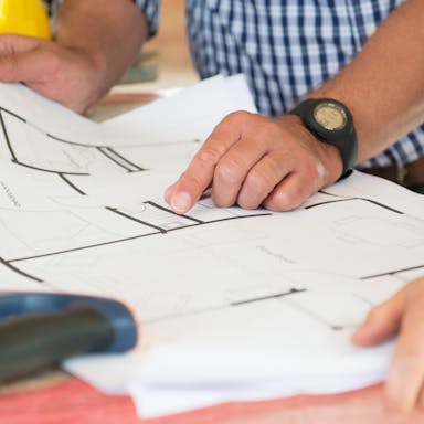 Architect Showing Plan On Blueprint - building codes and standards for construction.