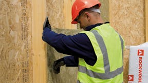 Builder installing ROCKWOOL insulation - Timber frame construction