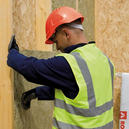 Builder installing ROCKWOOL insulation - Timber frame construction