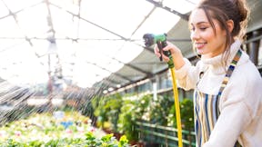 Girl watering green house