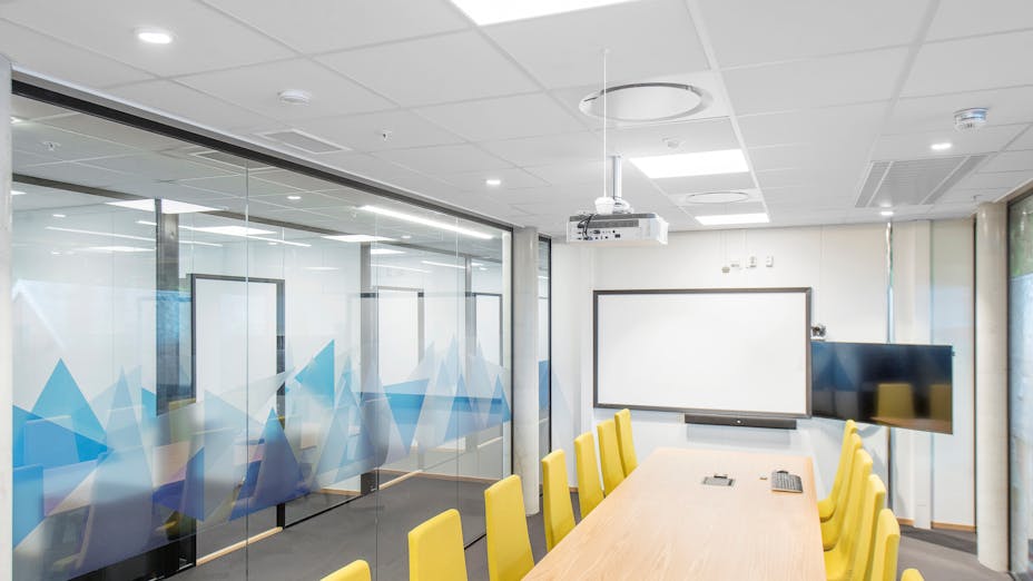 Rockfon acoustic ceiling tiles and panels and Chicago Metallic suspension grid system installed in office meeting room.