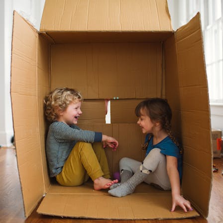 Children playing indoor.
Brother and sister playing together inside a cardboard box on the floor. People, children, kids, siblings, playing,