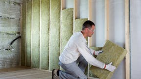 Man installing insulation, Self-builder, Renovation, Timber Frame Wall