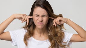 Woman putting her fingers in her ears