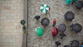 Birds-eye view, umbrellas in street, rain. 
Photo used first in the Sustainability Report 2017