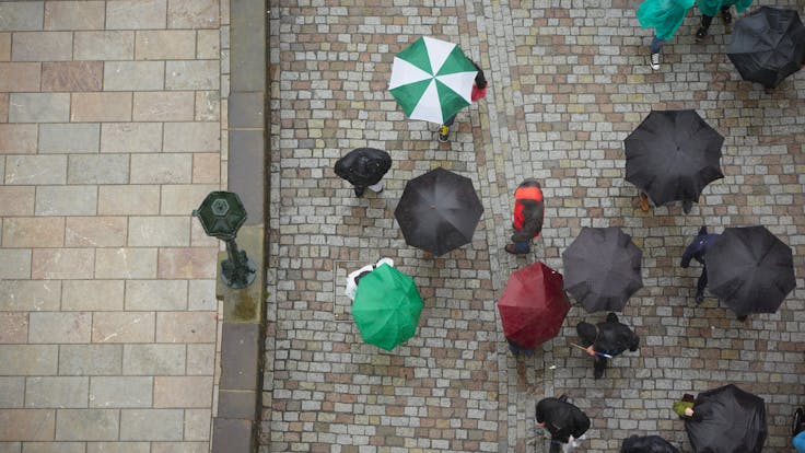 Birds-eye view, umbrellas in street, rain. 
Photo used first in the Sustainability Report 2017