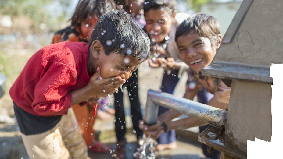 Young boys having fun at water well