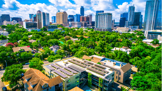 Sustainable urban development practices with homes and buildings integrated into the natural environment. The future of Austin Texas a renewable energy sustainable city.