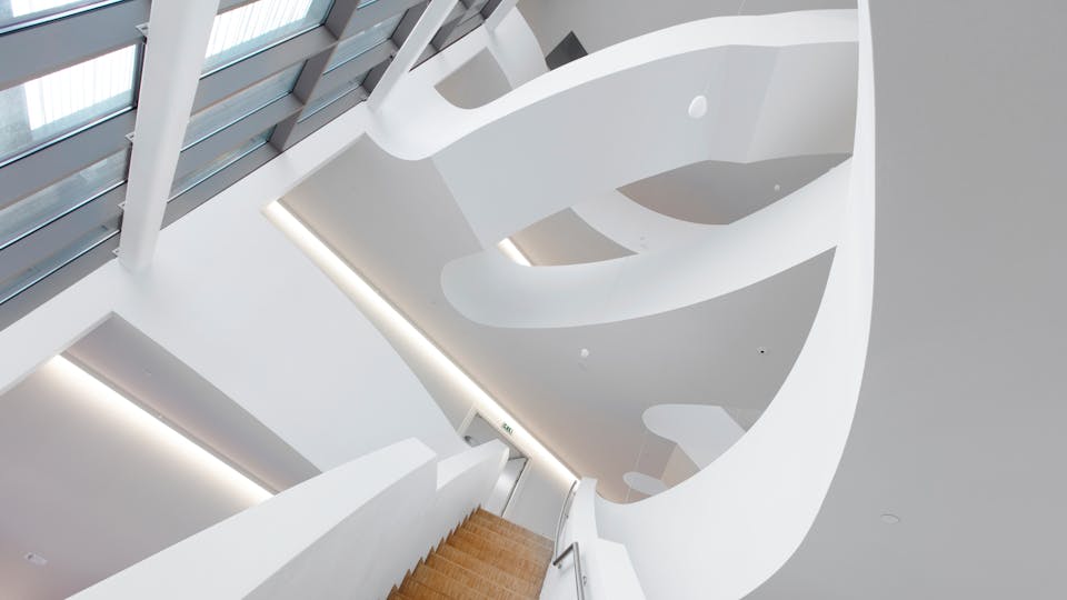 Stairwell called a vertical street where noise is controlled  using a seamless acoustic ceiling