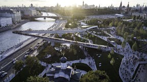Moscow, Park Zariadye, soaring bridge, city, nature, people, architecture. September 2017.  Green grass, trees and a church in the city centre. Sunset view on the Kremlin