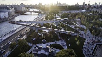 Moscow, Park Zariadye, soaring bridge, city, nature, people, architecture. September 2017.  Green grass, trees and a church in the city centre. Sunset view on the Kremlin
