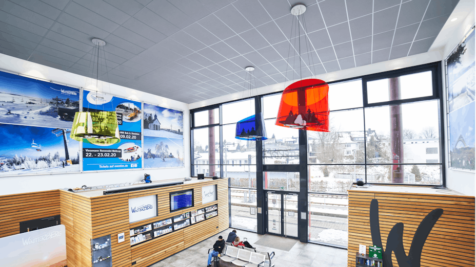 Guichet de gare avec des éléments colorés et un plafond moderne