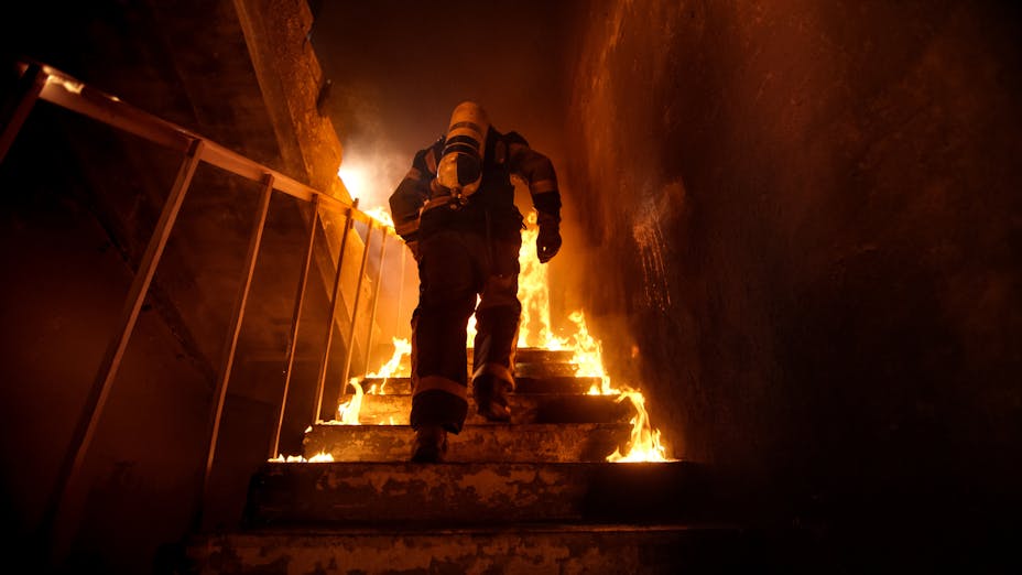 Fireman walking up staircase in burning building