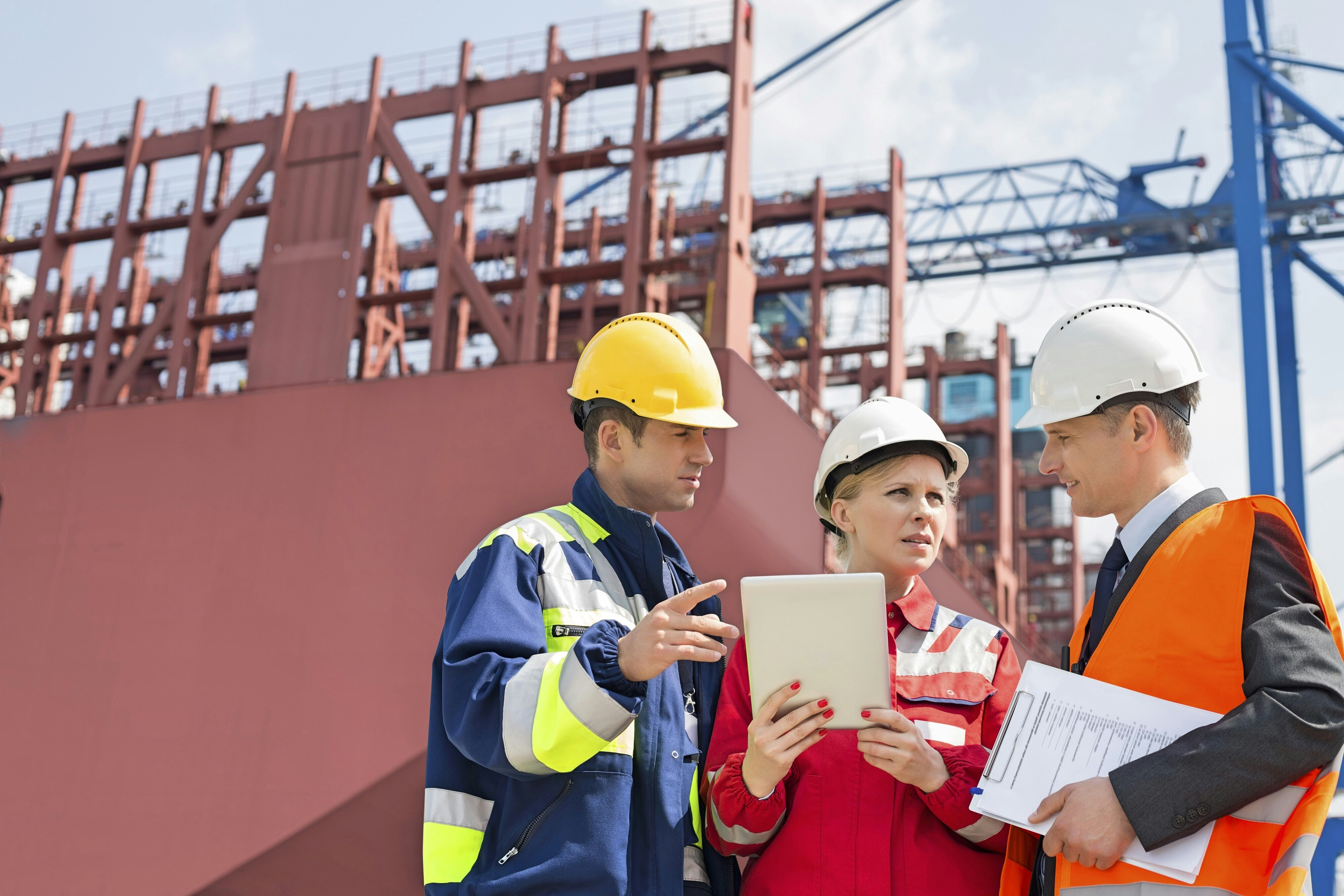 Workers discussing in shipping yard. people