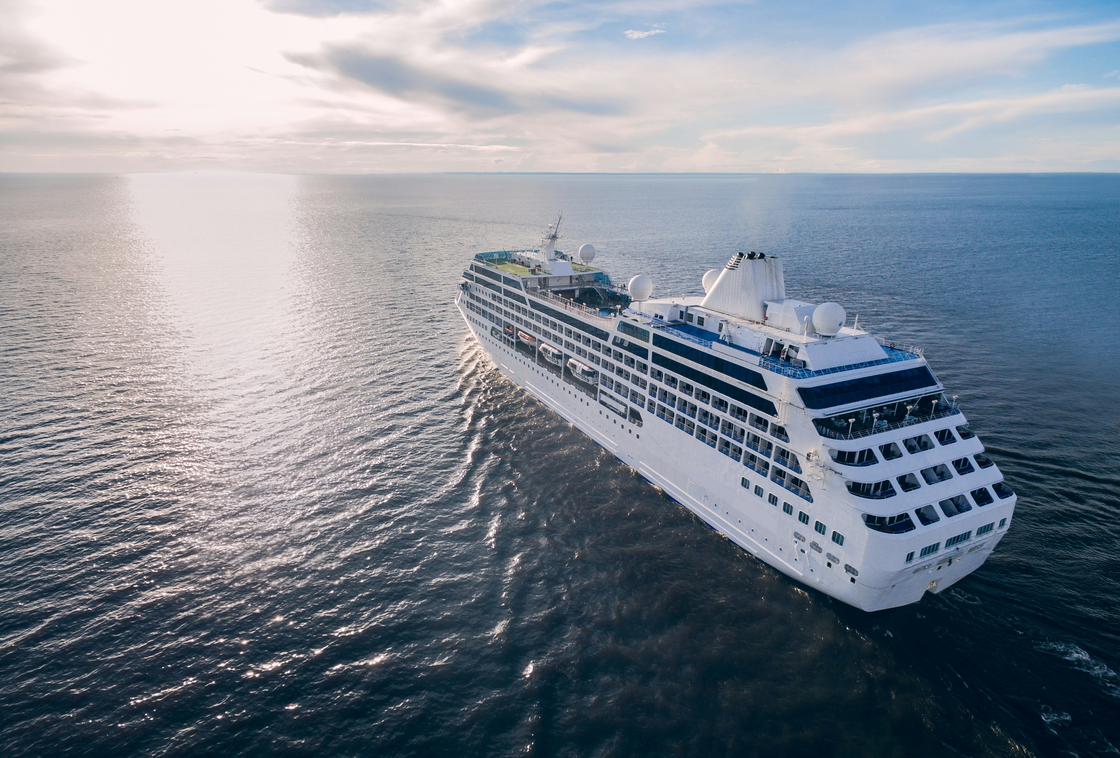 Aerial view of cruise liner sailing in the open sea at sunset