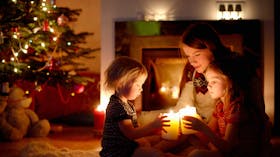 Family in front of Christmas tree, candles
