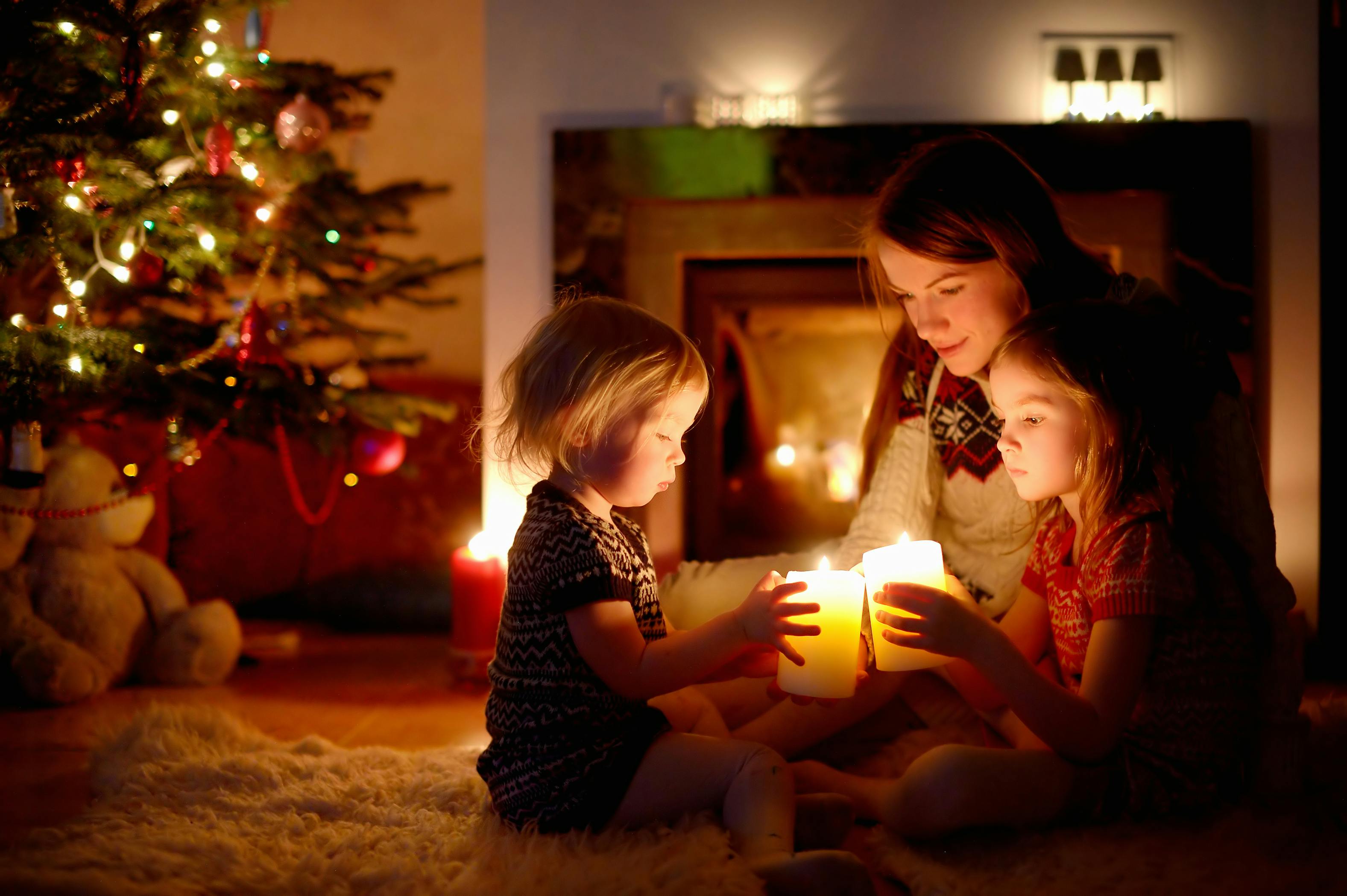 Family in front of Christmas tree, candles