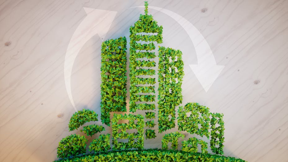 City built from leaves with recycling icon