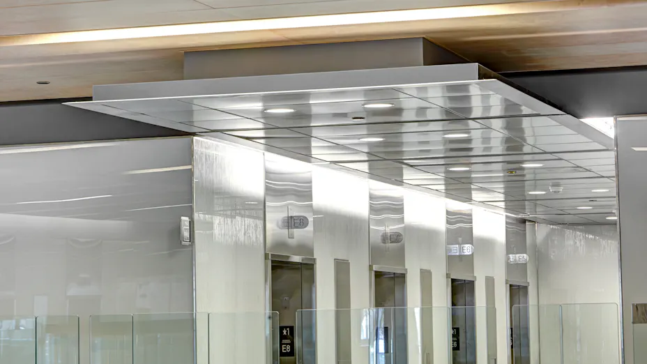 Rockfon Razor edge infinity and planostile lay-in, and spanair hook-on metal ceiling suspension systems installed in office building.