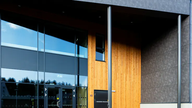 Sports hall 'Lärkan' in Sala, Sweden cladded with Rockpanel Stones Mineral Rust and Basalt Iron facade cladding.