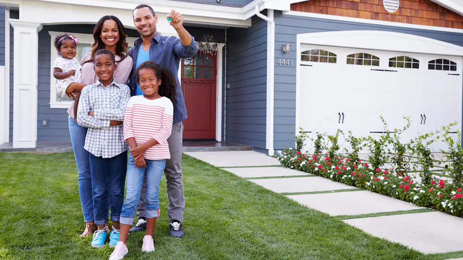 Happy family in front of a nice house.