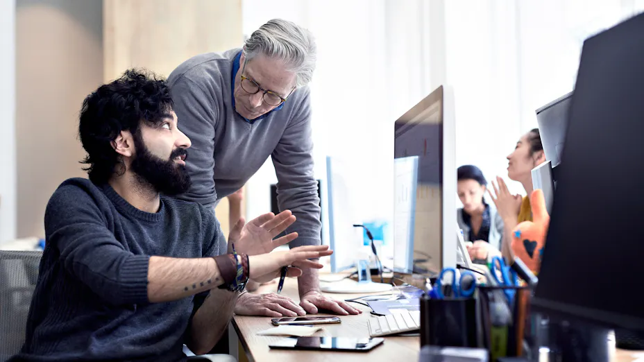 Two men talking together in an office.
